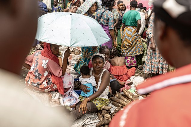 A woman selling vegetables carries her baby while waiting for customers at a roadside market as residents gradually return to the streets in Goma on January 31, 2025. The Rwandan-backed armed group M23 moved south as it closed in on a key military airport in DR Congo on January 31, 2025, a day after pledging to take the capital Kinshasa and as international criticism mounted The group's capture of most of Goma, the capital of North Kivu province, earlier in the week was a dramatic escalation in a region that has seen decades of conflict involving multiple armed groups. (Photo by Michel Lunanga/AFP Photo)