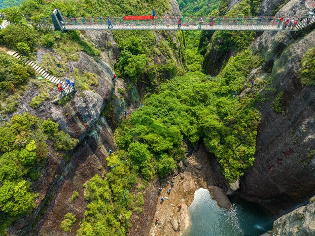 Volunteers descend the cliffs via safety ropes to clean garbage left by tourists on the cliffs on the Earth Day on April 22, 2025 in Taizhou, Zhejiang Province of China. (Photo by Xu Weijie/VCG via Getty Images)