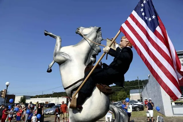 A float made by the “Augusta County For Trump” group depicts Republican presidential candidate Donald Trump riding a horse and carrying a Betsy Ross U.S. flag and the United States Constitution for the Buena Vista, Va., Labor Day Parade on Monday, September 5, 2016. (Photo by Heather Rousseau/The Roanoke Times via AP Photo)