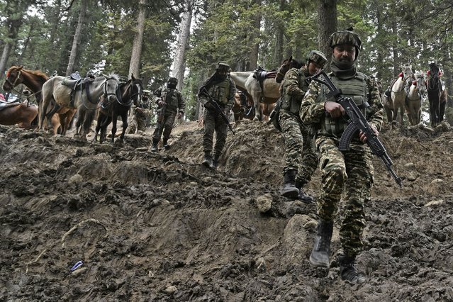 Indian soldiers trek back after a search operation around Baisaran meadow in the aftermath of an attack in Pahalgam, about 90kms (55 miles) from Srinagar on April 23, 2025. Indian security forces in Kashmir carried out a major manhunt on April 23, a day after gunmen opened fire on tourists killing 26 people in the region's deadliest attack on civilians since 2000. (Photo by Tauseef Mustafa/AFP Photo)