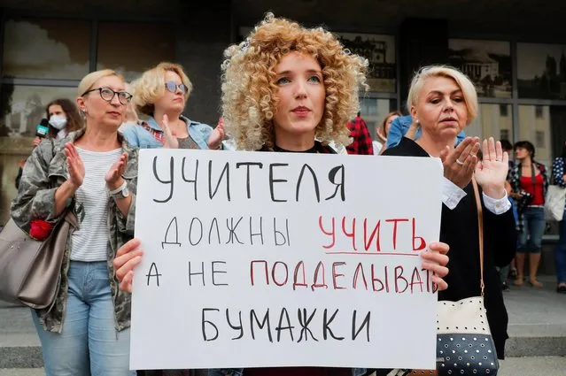 A woman holds a placard reading “Teachers should teach, not forge papers” as people take part in a rally against presidential election results near the Ministry of Education in Minsk, Belarus on August 25, 2020. (Photo by Vasily Fedosenko/Reuters)