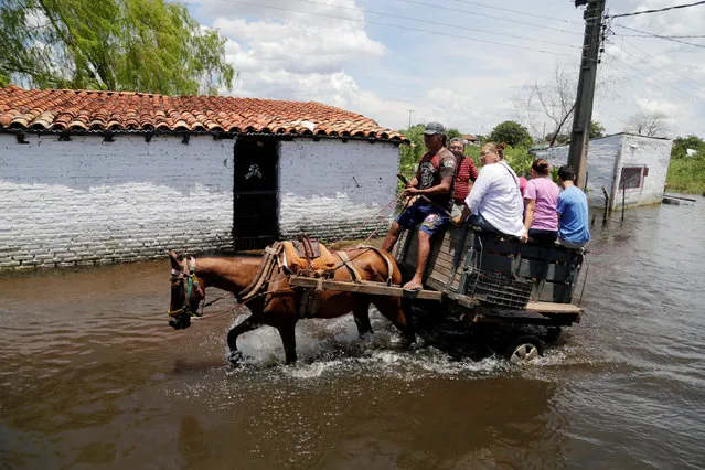 People ride on a horse carriage through a flooded street after heavy rains caused the river Paraguay to overflow, in Asuncion, Paraguay January 22, 2018. (Photo by Jorge Adorno/Reuters)