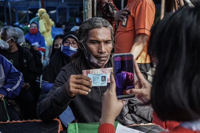 Postal officers take pictures of residents who have received social assistance, which is provided to poor people affected by Covid-19 in Makassar, Indonesia. (Photo by Herwin Bahar/ZUMA Wire/Rex Features/Shutterstock)