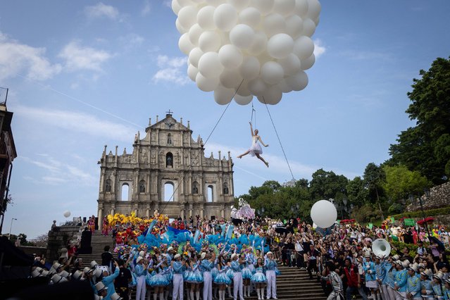 A performer dances over the Ruins of Saint Paul during the Macau International Parade in Macau on March 24, 2024. (Photo by Eduardo Leal/AFP Photo