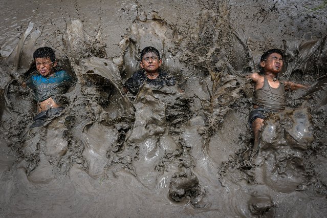 Children splash mud as they celebrate “National Paddy Day”, which marks the start of the annual rice planting season, at a paddy field in Jeetpur Phedi village on the outskirts of Kathmandu on June 29, 2025. (Photo by Prakash Mathema/AFP Photo)