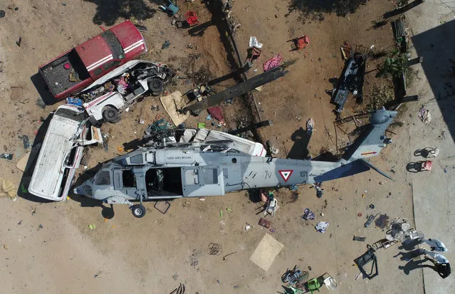 Aerial view of the military helicopter that fell on a van in Santiago Jamiltepec, Oaxaca state, Mexico, on February 17, 2018. A 7.2-magnitude earthquake rattled Mexico on Friday, causing little damage but triggering a tragedy when a minister's helicopter crash-landed on the way to the epicenter, Oaxaca, killing thirteen people, including three children, on the ground. (Photo by Mario Vazquez/AFP Photo)