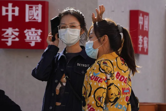 Shoppers wearing masks to protect from the coronavirus walk by the words “China Li-Ning” for Chinese sports goods brand Li-Ning in Beijing on Sunday, October 4, 2020. This year, travel restrictions due to the coronavirus pandemic mean that some 600 million tourists — about 40% of the population — will travel within China during the weeklong National Day holidays that began last Thursday, according to Ctrip, China's largest online travel agency. (Photo by Ng Han Guan/AP Photo)