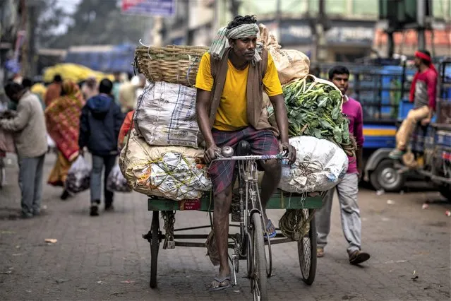 A man on his tricycle carries transports vegetables at a wholesale market in Guwahati, India, Wednesday, February 1, 2023. Indian Prime Minister Narendra Modi's government ramped up capital spending by a substantial 33% to $122 billion in an annual budget presented to Parliament on Wednesday, seeking to spur economic growth and create jobs ahead of a general election next year. (Photo by Anupam Nath/AP Photo)