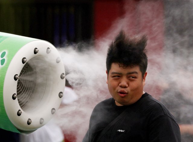 A tourist cools off in front of a misting fan near a venue of the Hozuki-Ichi (Japanese lantern plant fair), at Sensoji temple, in Tokyo, Japan, on July 10, 2025. (Photo by Kim Kyung-Hoon/Reuters)