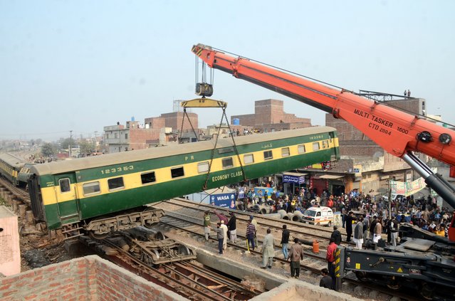 Rescue workers use a crane to clear the tracks after a train derailed, in Lahore, Pakistan, 31 January 2025. Three bogies of the Karachi-bound Shalimar Express derailed near Shahdara, Lahore, causing train service suspensions between several cities and affecting multiple trains. Relief operations are underway to clear the tracks and restore normal service. (Photo by Rahat Dar/EPA)