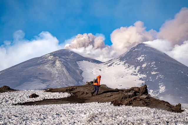 A person stands in front of Mount Etna as volcanic steam rises, Italy, on February 12, 2025. (Photo by Giuseppe Di Stefano/Etna Walk via Reuters)