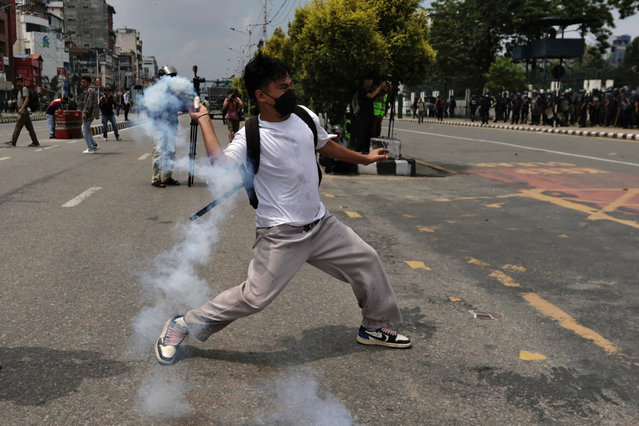 A demonstrator hurls a tear smoke shell towards members of riot police during a protest against corruption and the government’s decision to block several social media platforms, in Kathmandu, Nepal on September 8, 2025. (Photo by Navesh Chitrakar/Reuters)