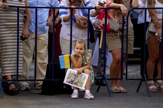 A child holds a photograph of a Ukrainian serviceman during an event of solidarity with Ukraine, marking its upcoming Aug. 24 Independence Day, in Bucharest, Romania, Thursday, August 21, 2025. (Phoot by Andreea Alexandru/AP Photo)