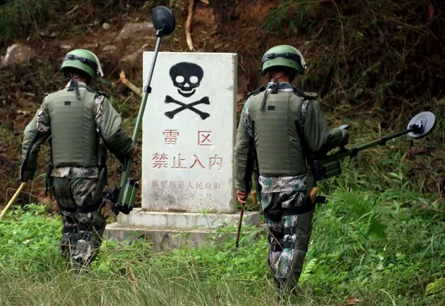 Chinese People's Liberation Army soldiers (PLA) work to remove mines laid by China during the China-Vietnam conflict in the 1980s in Maguan county, Yunnan province, November 2, 2015. According to China Daily, China started a mission in Yunnan province with 400 soldiers on the border with Vietnam on Tuesday, aiming to remove more than 470,000 mines before the end of 2017. (Photo by Reuters/China Daily)