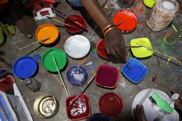 Indian women paint miniature models of houses as they make them for sale ahead of Diwali festival, in Prayagraj, India, Thursday, November 12, 2020. People buy them to decorate their homes during Diwali, the annual Hindu festival of lights which will be celebrated on Nov 14. (Photo by Rajesh Kumar Singh/AP Photo)