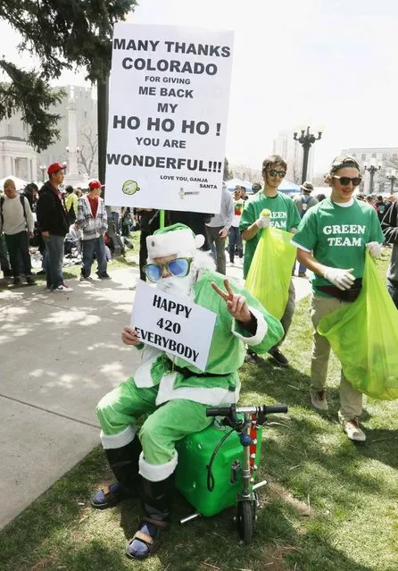 A man dressed in a green Santa suit holds a sign referring to Colorado legalizing marijuana at the 4/20 marijuana holiday in Civic Center Park in downtown Denver April 20, 2013. (Photo by Rick Wilking/Reuters)