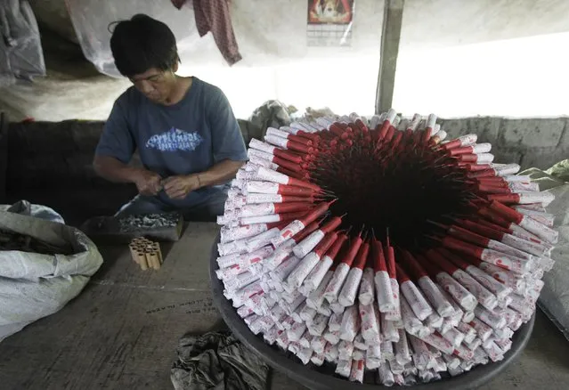 A worker makes fireworks next to unfinished pyrotechnics at a makeshift factory in Bocaue town, Bulacan province, north of Manila December 27, 2014. (Photo by Romeo Ranoco/Reuters)