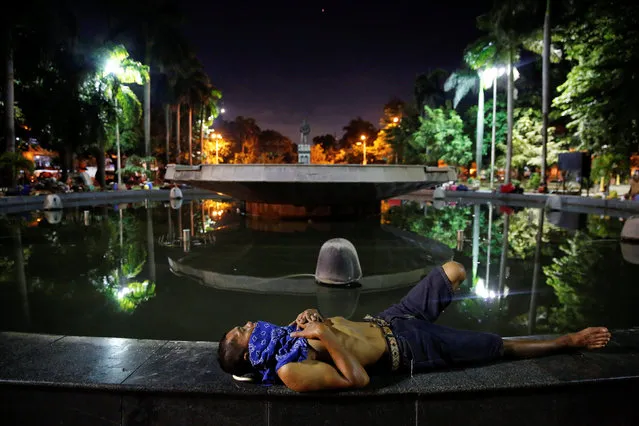 People sleep in the open around a fountain in Manila, Philippines early October 24, 2016. People who have been spending their nights in public places for a longer time, say there are more people joining them since the beginning of the country's war on drugs. (Photo by Damir Sagolj/Reuters)