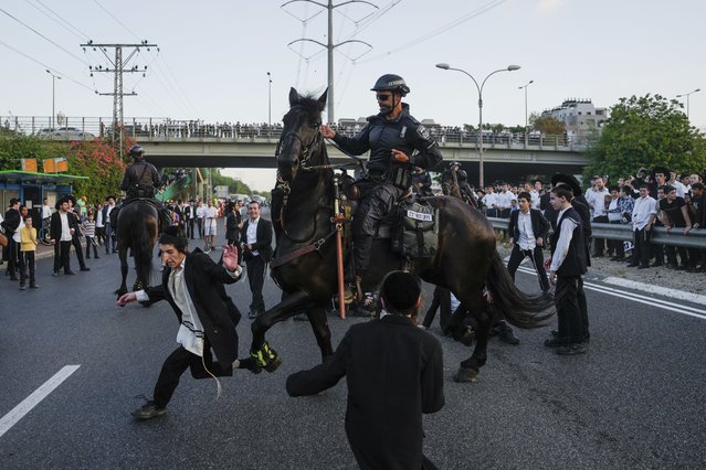 Israeli mounted police disperse Ultra-Orthodox Jews blocking a highway during a protest against military recruitment in Bnei Brak, near Tel Aviv, Israel, Tuesday, July 16, 2024. The Israeli military on Tuesday said it would begin sending draft notices to Jewish ultra-Orthodox men next week, a step that could destabilize Prime Minister Benjamin Netanyahu's government and trigger more large protests in the community. (Photo by Ohad Zwigenberg/AP Photo)