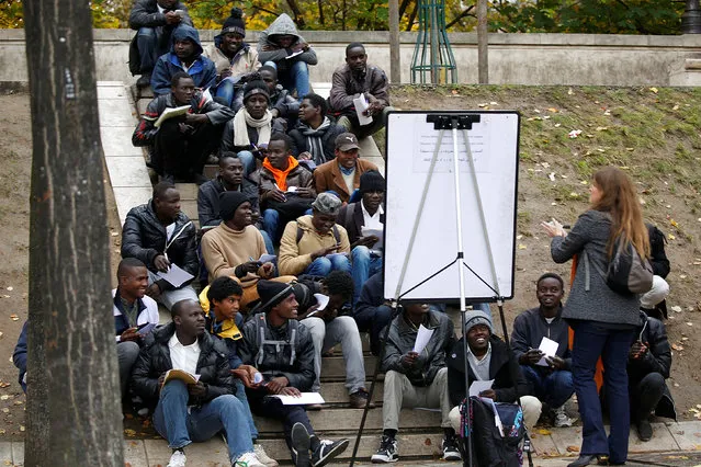 Migrants attend a French lesson near their makeshift camp in Paris, France, October 28, 2016. The number of migrants sleeping rough on the streets of Paris has risen by at least a third since the start of the week, with some of the newcomers coming from the northern France camp of Calais that started being dismantled on Monday, officials said. (Photo by Charles Platiau/Reuters)