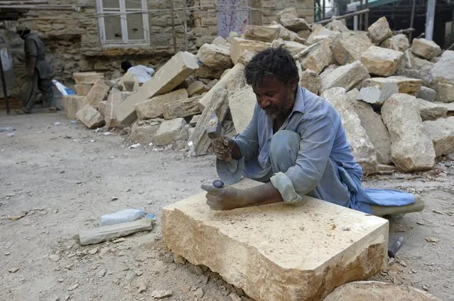 A labourer shapes mountain stone to be used in the renovation of a building in Karachi, Pakistan November 13, 2015. (Photo by Akhtar Soomro/Reuters)