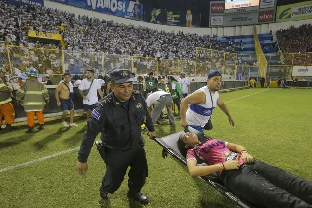 An injured fan in carried to the field of Cuscatlan stadium in San Salvador, El Salvador, Saturday, May 20, 2023. (Photo by Milton Flores/AP Photo)