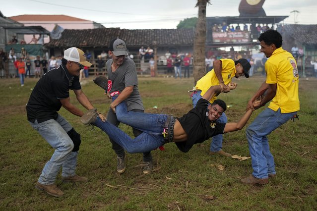 A man is carried by his friends to throw him into the mud during the annual folk festival that celebrates the feast day of Our Lady of Mercedes in Guarare, Panama, Friday, September 27, 2024. (Photo by Matias Delacroix/AP Photo)