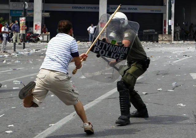 A protester clashes with a police officer in Athens' central Syntagma (Constitution) Square in this June 15, 2011 file photo. Greece triggered the regional financial crisis in 2009 when a far higher budget deficit than previously calculated emerged. (Photo by Yannis Behrakis/Reuters)