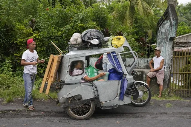 Residents living near Mayon Volcano in Daraga, Albay province, northeastern Philippines prepare to move to an evacuation center on Sunday, June 11, 2023. (Photo by Aaron Favila/AP Photo)
