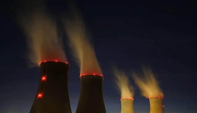Steam rises at night from the cooling towers of the Electricite de France (EDF) nuclear power station in Dampierre-en-Burly, March 8, 2015. (Photo by Christian Hartmann/Reuters)