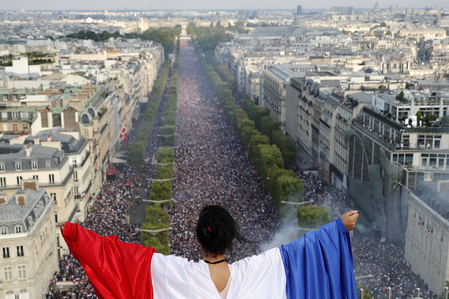 A French supporter waves a French flag as she celebrates after France won the 2018 World Cup at the Champs-Elysees venue during the FIFA World Cup 2018 final match between France and Croatia in Paris, France, 15 July 2018. France won 4-2. (Photo by Guillaume Horcajuelo/EPA/EFE)