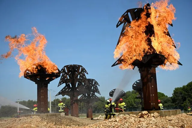 Firefighters recruits complete their training at the fire brigade of the Bouches-du-Rhone department training centre (Centre de formation departemental) in Velaux, southern France, on June 16, 2023. (Photo by Nicolas Tucat/AFP Photo)