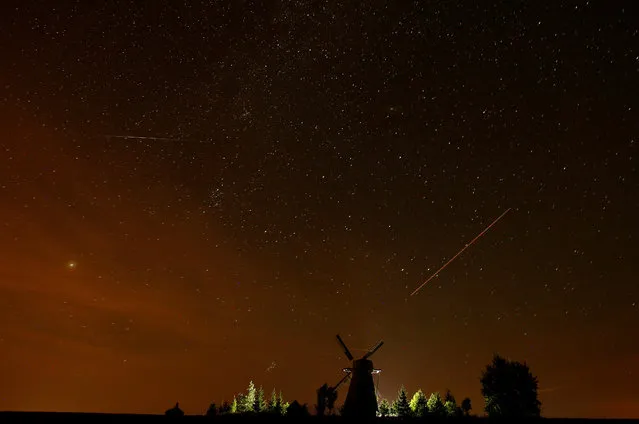 A meteor (L) and plane (R) tracks are seen in the night sky during the Perseid meteor shower near the village of Ptich, Belarus, August 13, 2018. (Photo by Vasily Fedosenko/Reuters)
