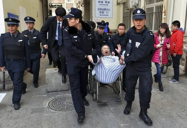 Police officers carry a man (C) out of a hospital as they enforce a court order in Beijing February 10, 2015.  The man, 55, surnamed Chen, received treatment at the hospital after a traffic accident in August 2011. Chen returned to the hospital two months later, saying he had pains in his left leg and as a protest, he refused to be discharged even though the hospital stopped providing any further treatment in July 2012. (Photo by Reuters/Stringer)