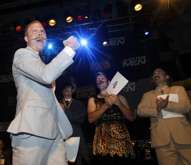Nick Ackerman, far left, celebrates his first place win for the gold medal in the English Moustache division as competitors Patrick Fette, Brian Wele and Daniel Bernhardt congratulate him during the fourth annual Just For Men National Beard and Moustache Championships Saturday, September 7, 2013 at The House of Blues in New Orleans. More than 150 contestants competed in 18 different categories including Dali, full beard natural and sideburns. (Photo by Susan Poag/AP Photo)
