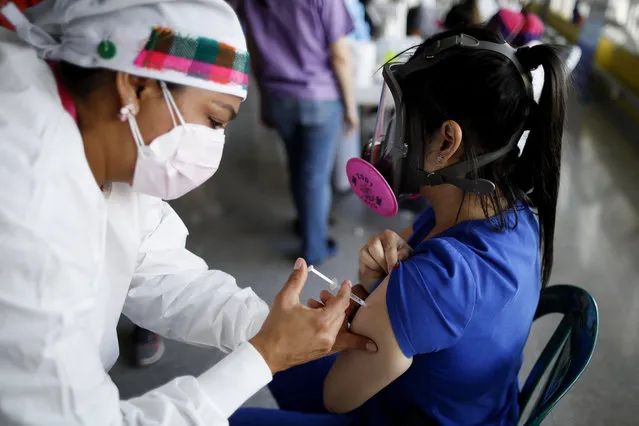 In this April 23, 2021, file photo, a health care worker inoculates Dr. Virma Rivas with the Sputnik V COVID-19 vaccine, as part of a vaccination campaign in Tegucigalpa, Honduras. Honduras has obtained a paltry 59,000 vaccine doses for its 10 million people. Similar gaps in vaccine access are found across Africa, where just 36 million doses have been acquired for the continent's 1.3 billion people, as well as in parts of Asia. (Photo by Elmer Martinez/AP Photo/File)