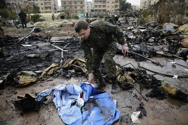 A Russian soldier checks a burned medical tent after rebels launched a mortar shell at a field hospital in west Aleppo, Syria, Monday, December 5, 2016. Rebel shelling of the government-held part of Syria's Aleppo city Monday killed a Russian female nurse in a makeshift Russian hospital in the city, a Russian officer there said. (Photo by Hassan Ammar/AP Photo)