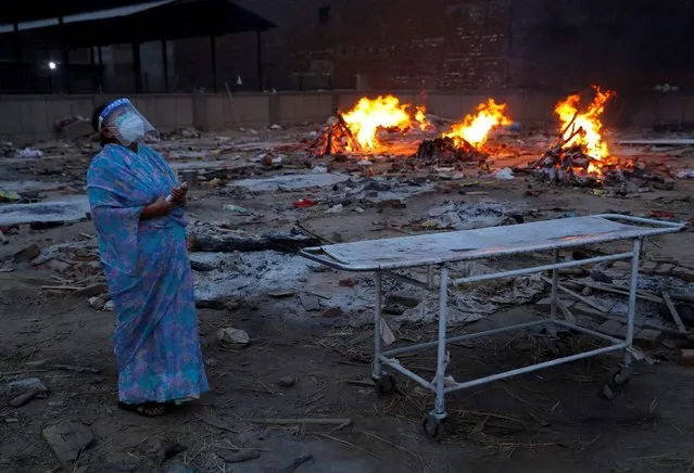 A woman cries during the cremation of her husband, who died from COVID-19, at a crematorium in New Delhi, India, May 5, 2021. (Photo by Adnan Abidi/Reuters)