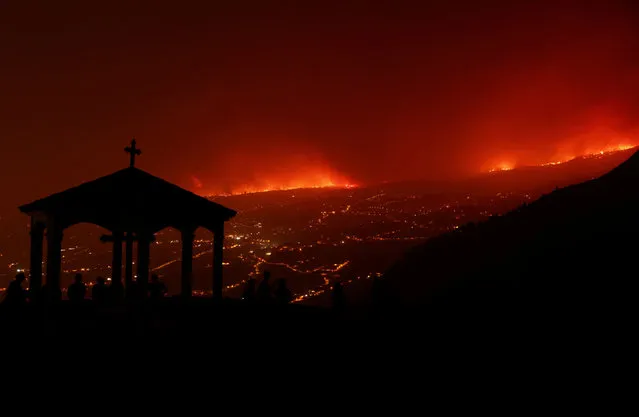 A view shows a fire over the mountains near empty houses after the evacuation in different villages in the north, as wildfires rage out of control on the island of Tenerife, Canary Islands, Spain on August 20, 2023. (Photo by Nacho Doce/Reuters)