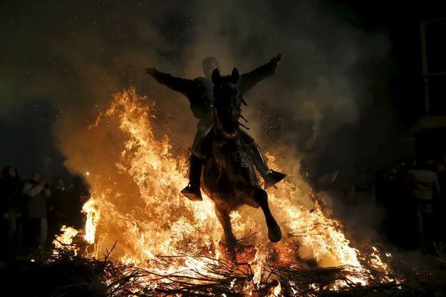 A man rides a horse through the flames during the “Luminarias” annual religious celebration on the eve of Saint Anthony's day, Spain's patron saint of animals, in the village of San Bartolome de Pinares, northwest of Madrid, Spain, January 16, 2016. (Photo by Susana Vera/Reuters)