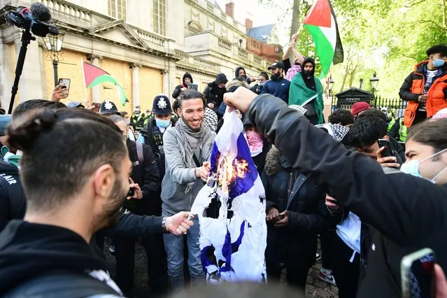 Protester set fire to a Israeli flag as they gather near to the Israeli embassy in Kensington, central London on Saturday, May 22, 2021, after a march in solidarity with the people of Palestine, following a ceasefire agreement between Hamas and Israel. (Photo by Ian West/PA Images via Getty Images)
