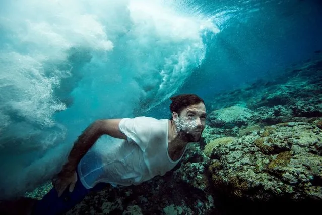 Mike diving beneath a shallow wave. (Photo by Mark Tipple/Caters News Agency)