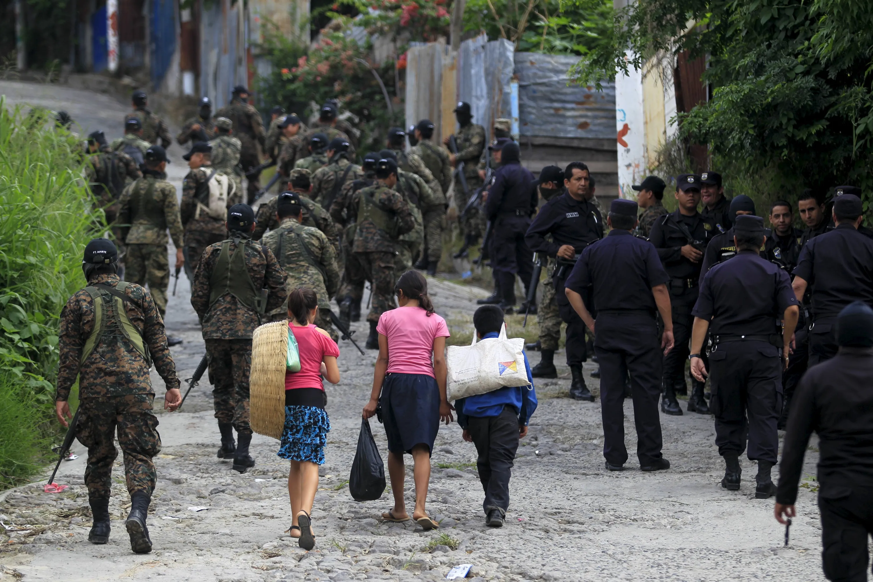 Next picture →. Police officers and soldiers patrol a neighbourhood in San Marcos...