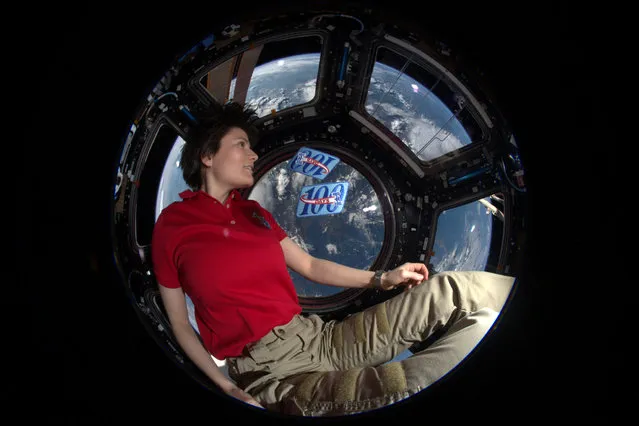 Italian ESA astronaut Samantha Cristoforetti poses in the Cupola module of the International Space Station with two 100-day patches to mark her 200th day in space on June 10, 2015. Samantha first flew to the International Space Station on a Soyuz spacecraft in 2014 for a mission known as “Futura”. (Photo by ESA/NASA)