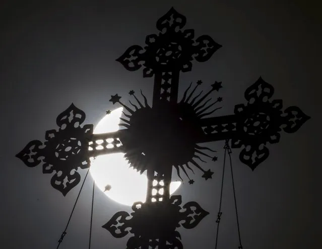 A cross on the dome of the Cathedral of Christ the Saviour is seen during a partial solar eclipse in Moscow, March 20, 2015. A solar eclipse thrilled thousands of sky gazers on remote Arctic islands on Friday but clouds disappointed some viewers of a rare celestial show that was also partly visible for millions in Europe, Africa and Asia. (Photo by Maxim Shemetov/Reuters)