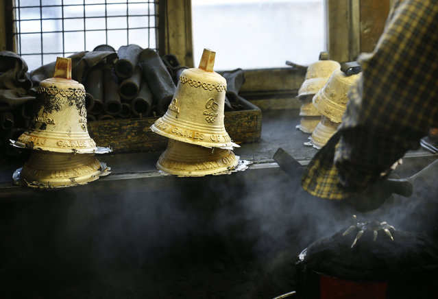 Serge Huguenin of the Blondeau foundry takes the newly melted bell out of the mould in La Chaux-de-Fonds, Switzerland January 21, 2016. (Photo by Denis Balibouse/Reuters)