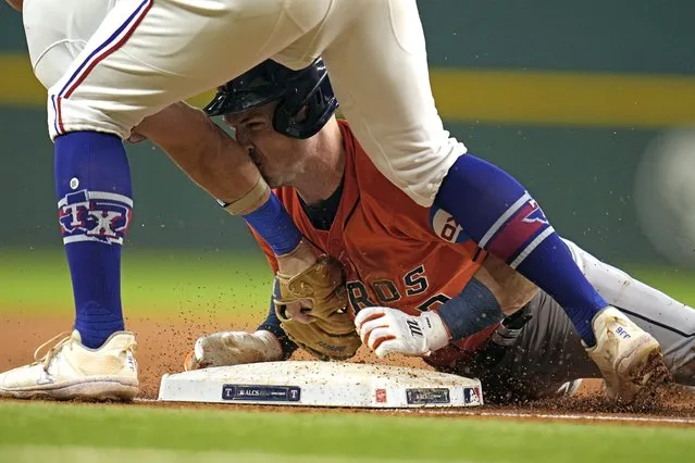 Houston Astros' Alex Bregman, right, slides safely into third base after hitting a two-run triple as Texas Rangers third baseman Josh Jung tags him during the first inning in Game 4 of the baseball American League Championship Series Thursday, October 19, 2023, in Arlington, Texas. (Photo by Julio Cortez/AP Photo)