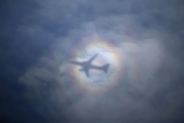 The sun casts a shadow and spectral halo effect on clouds as U.S. Secretary of State's aircraft departs from Tel Aviv for Geneva, on November 10, 2013. (Photo by Jason Reed/AFP Photo)