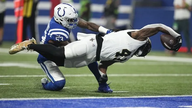 New Orleans Saints running back Alvin Kamara (41) reaches to score on an 18-yard touchdown reception as Indianapolis Colts linebacker Shaquille Leonard (53) defends during the first half of an NFL football game Sunday, October 29, 2023 in Indianapolis. (Photo by Darron Cummings/AP Photo)