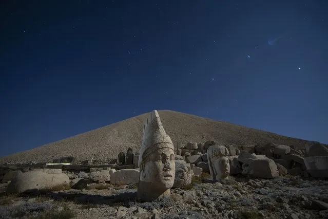 Ancient statues are seen as stargazers gather to watch the Perseid meteor shower atop Mount Nemrut in southeastern Turkey, Saturday, August 13, 2022. Hundreds spent the night at the UNESCO World Heritage Site for the annual meteor show that stretches along the orbit of the comet Swift–Tuttle. Perched at an altitude of 2,150 meters (over 7,000 feet), the statues are part of a temple and tomb complex that King Antiochus I, of the ancient Commagene kingdom, built as a monument to himself. (Photo by Emrah Gurel/AP Photo)